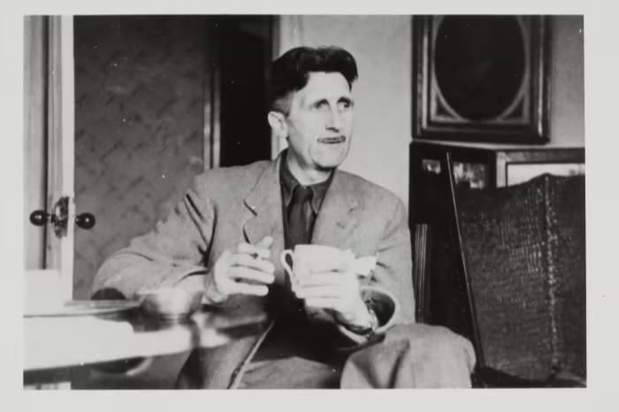 George Orwell relaxes with a cigarette and cup of tea in 1945