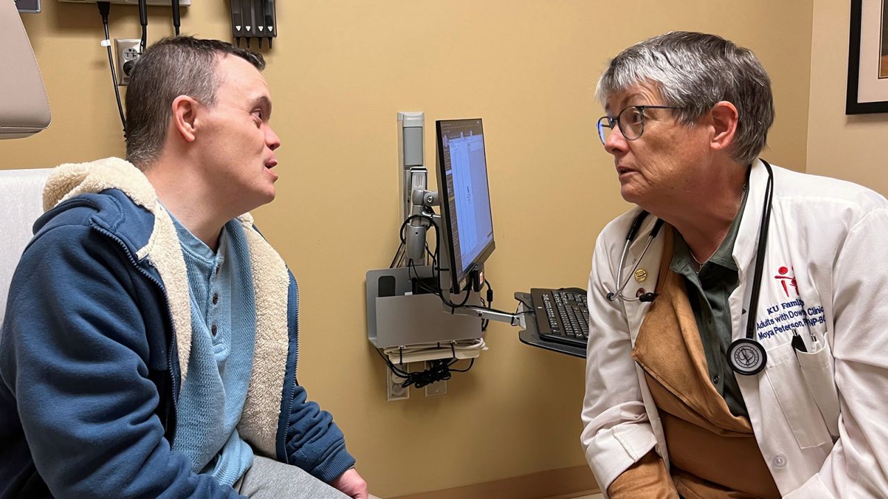 Nurse practitioner Moya Peterson speaks to Christopher Yeo of Hartford, Kansas. Peterson leads an rare clinic for adults with Down syndrome. 