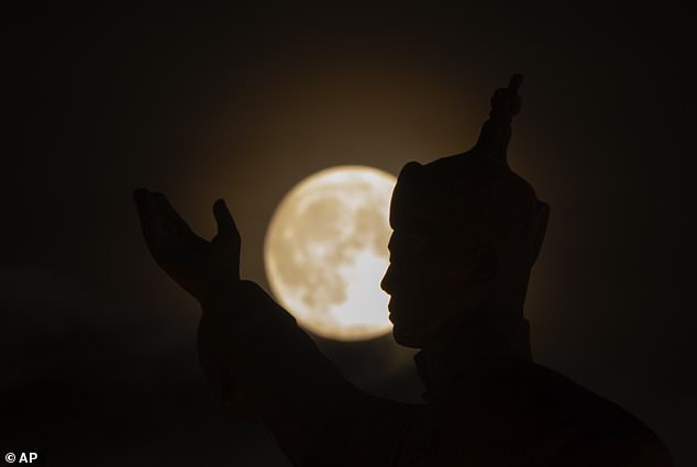 MONGOLIA: The supermoon rises near the equestrian statue of Damdin Sukhbaatar on Sukhbaatar Square in Ulaanbaatar, Mongolia