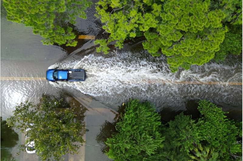 A truck drives along a flooded street in New Port Richey, Florida