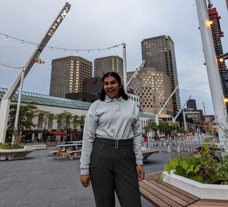 A woman looks excited standing outside.