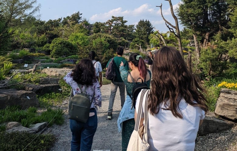 A group of people are seen walking outside.