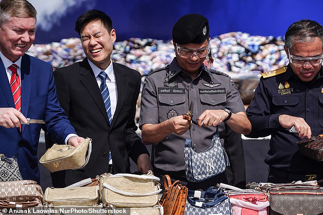 Thai officer shred up counterfeit handbags during a destruction ceremony of goods that infringe intellectual property rights in Bangkok, Thailand, on August 31, 2023