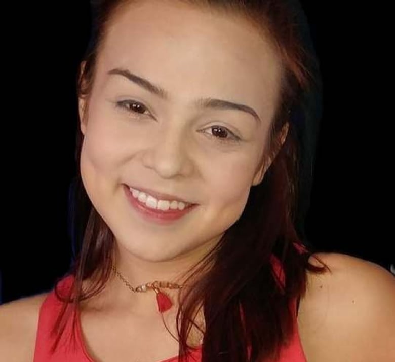 A young woman with shoulder length dark hair smiles at the camera. 