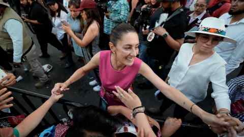 Claudia Sheinbaum greets supporters as she leaves a rally in Mexico City