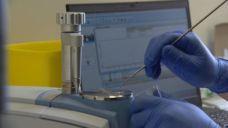 A technician at the Spectrum drug checking site on Jasper Avenue uses a spectrometer to test a drug sample. 