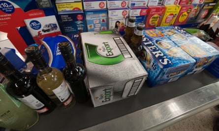 Cartons of beer and bottles of wines and spirits at a supermarket checkout