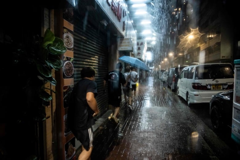 People run and shelter from the rain.