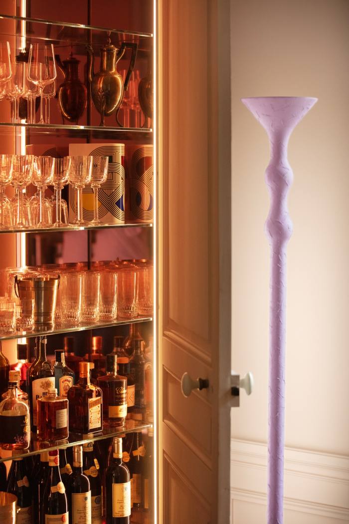 A hidden minibar beside a lamp from Parente’s Apertura collection