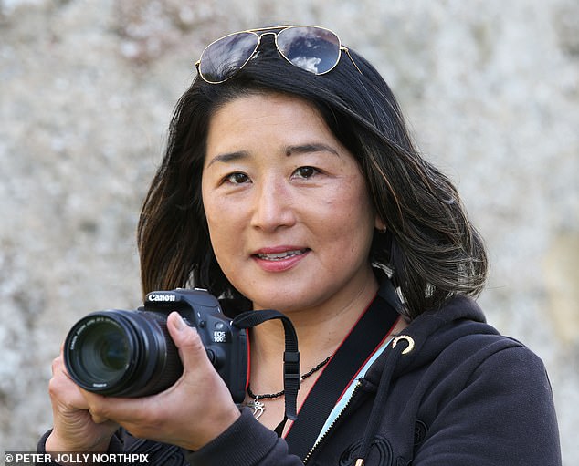 Chie Kelly, 51, was taking photographs from the village of Dores when she and her businessman husband Scott, 68, saw a strange 'serpent-like' creature moving over a distance of around 100 metres before disappearing