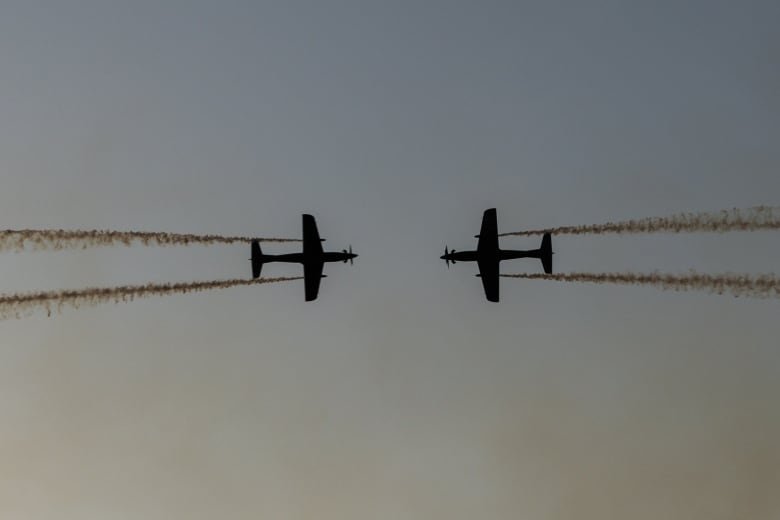 Two RAAF Roulettes performing in the sky and flying toward each other.