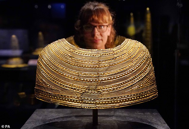 A member of staff observes the Mold Gold Cape dating from 1900-1600 BC which Welsh nationalists want returned