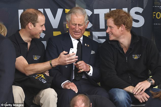 Princes William and Harry simile with their father King Charles, then the Prince of Wales, during the Invictus Games at the Lee Valley Athletics Centre in 2014