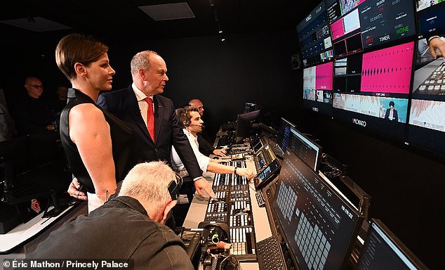 Prince Albert puts his arm around the waist of Princess Charlene before flicking a switch which launched the TV channel