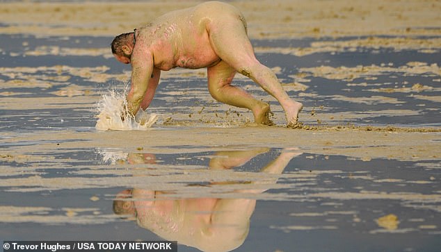 Dirty D of Los Angeles dives into the mud at Burning Man preferring to move around on all-fours