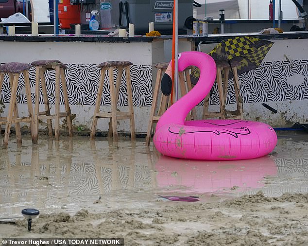 An abandoned pool float - usually worn ironically at the dry, dusty Burning Man - sits in a puddle of mud