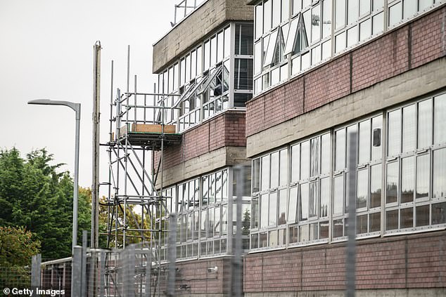 Public buildings containing RAAC have been deemed to pose no 'immediate risk to safety' to school pupils and hospital patients in Scotland. Pictured: Scaffolding is seen outside classrooms as repair work continues at Hornsey School for Girls in London