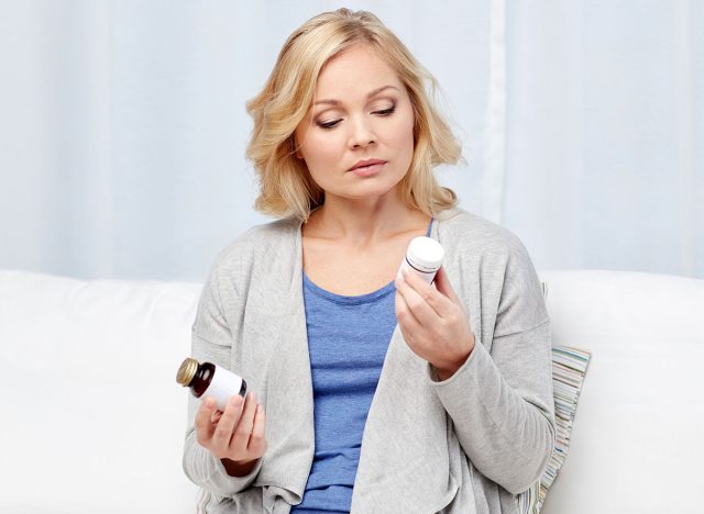 woman looking at medicine bottle