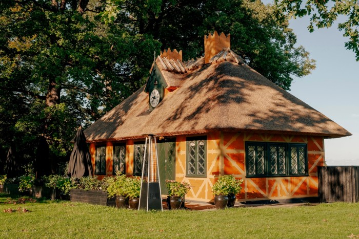 Den Gule Cottage: a restaurant in a historic cottage with a thatched roof, and orange and yellow-patterned walls