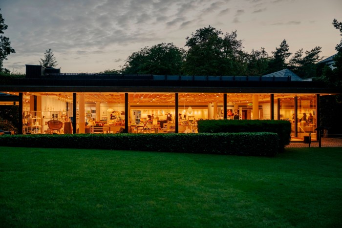 Part of the Louisiana at dusk, with orange lighting illuminating the gift shop 