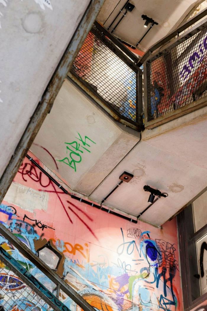 The concrete stairwell of a building is decorated with graffiti