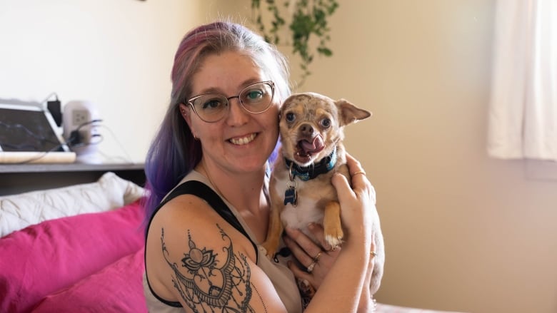 A woman holds a dog.