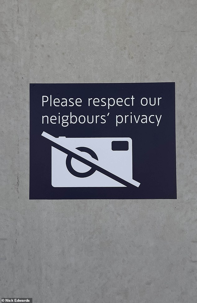 A sign bearing the symbol of a camera with a strike through it also tells visitors: 'Please respect our neighbours' privacy'