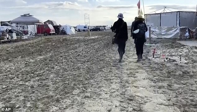 People are pictured wading through the mud in Nevada on Monday