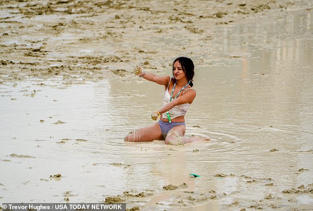 Shai Peza of Chicago dances in the mud after the rain on Saturday