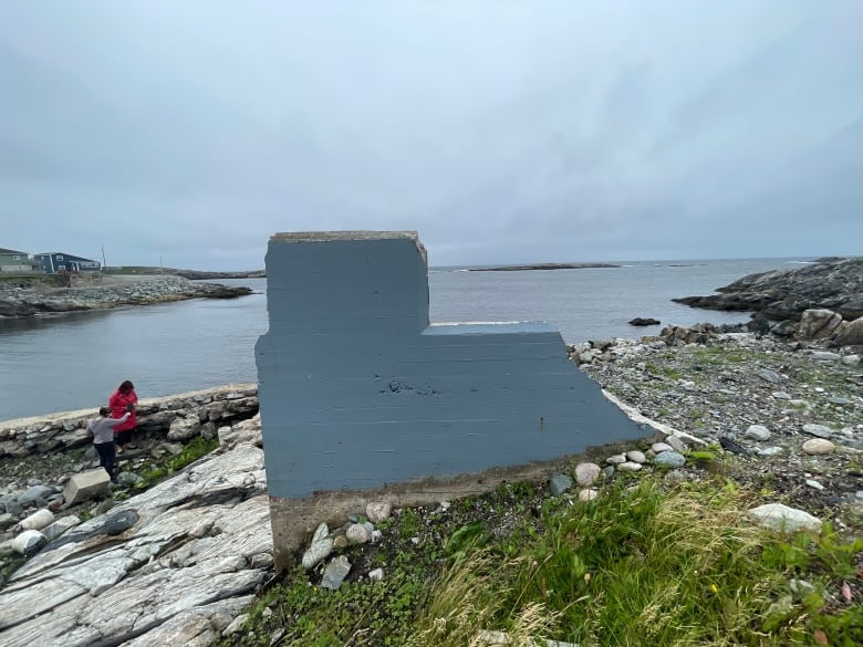 A blue piece of a now-demolished house stands alone.