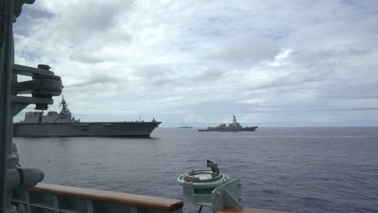 The view from the command bridge of the Royal Canadian Navy vessel. On the left, a Japanese carrier. On the right, the USS Ralph Johnson of the US Navy. In the middle, the Chinese destroyer keeping watch.