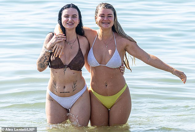 Vanessa McIntyre, 25, and Maddie Sykes, 26, from Australia, cool off at Brighton today