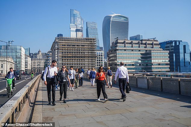 Pedestrians walk across London Bridge in the capital today amid the very hot weather