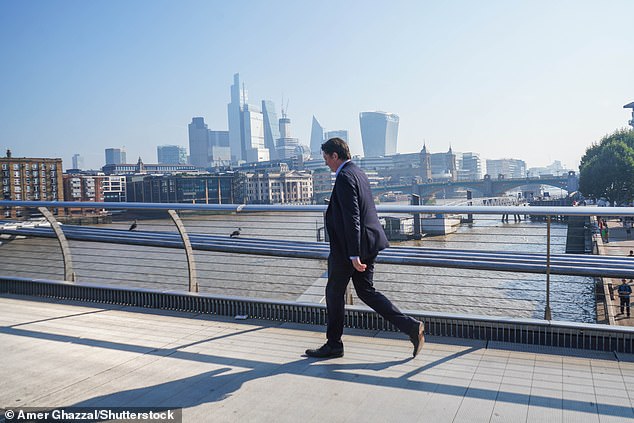 A man walks across Millennium Bridge in London today amid the very hot weather