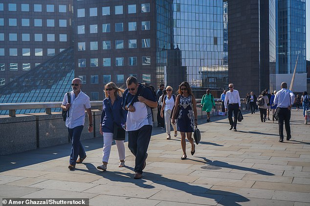 Pedestrians walk across London Bridge in the capital today amid the very hot weather