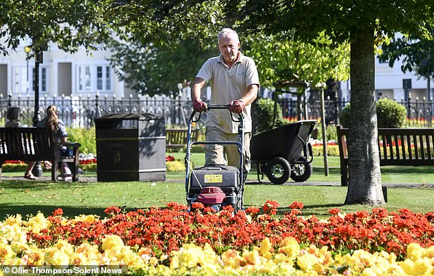 Landscaper Andrew Thompson mows the grass at the Abbey Gardens in Winchester today