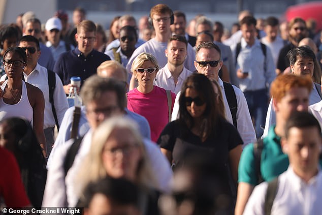 Commuters cross London Bridge this morning amid hot and sunny weather in the capital