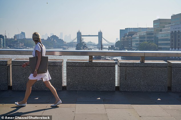 Pedestrians walking on London Bridge look across to Tower Bridge in the sunshine today