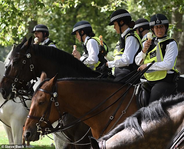 Mounted police officers enjoyed ice cream in the heat at St James's Park in London yesterday