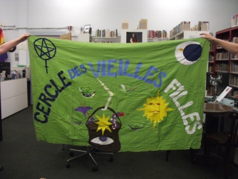 A banner that reads "le cercle des vieilles filles" with images of a cauldron, a sun, the moon, the venus symbol