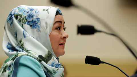 A woman in a head scarf in front of a microphone