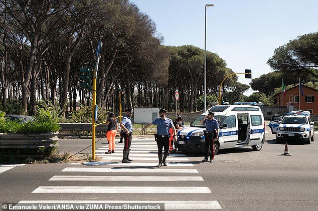 Two Irish tourists, aged 59 and 60, have been run over and killed in a horrific car crash in Rome. Pictured: Police officers at the scene today