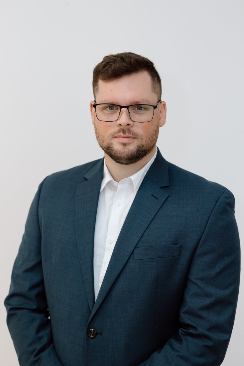 A man wearing glasses poses for a photo.