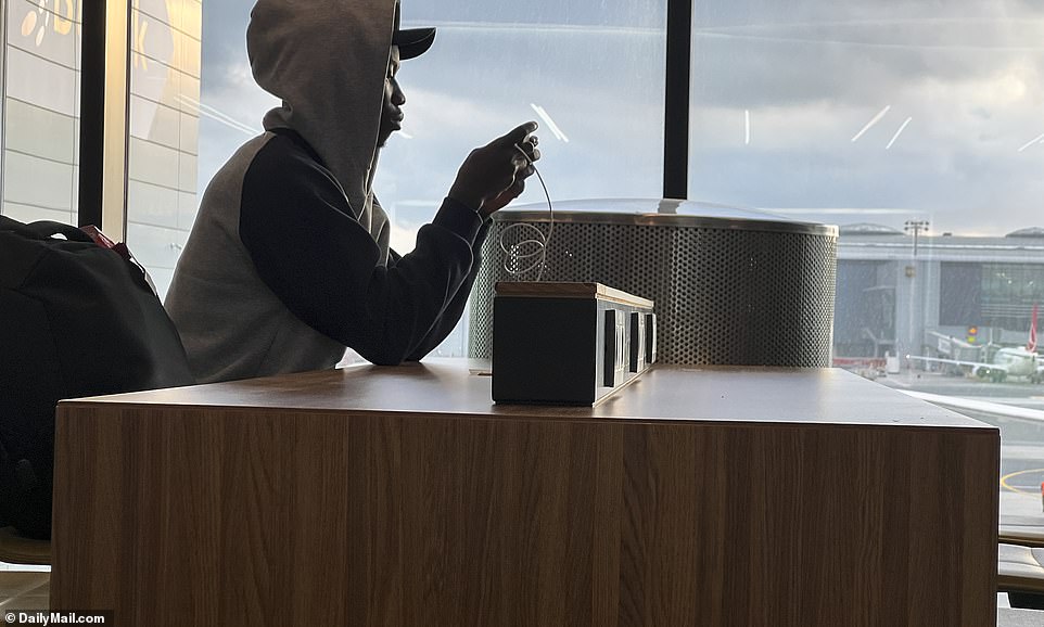 Whiling away the hours one migrant charges his cell phone in the Istanbul Airport