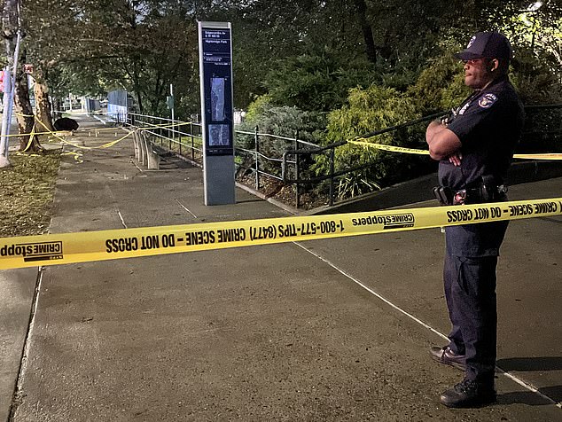 An NYPD officer can be seen standing guard following Friday night's killing in Washington Heights