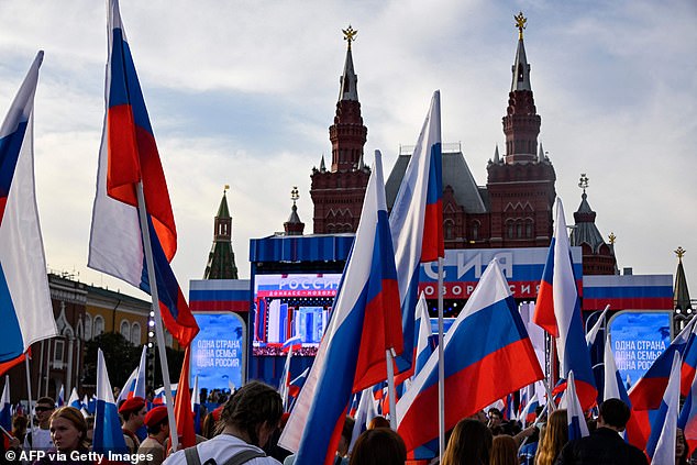 People waving Russian flags attend a concert dedicated to the first anniversary of the annexation of four regions of Ukraine Russian troops control