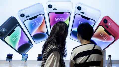 Customers look at Apple smartphones