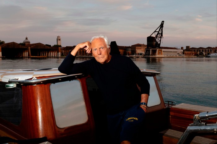 Fashion designer Giorgio Armani sat on a small boat docked in in the Venice lagoon