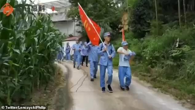 Chinese owners of planned Michigan EV plant make staff in the Communist state pledge allegiance to the Party and wear Red Army uniforms on bizarre field trips in China