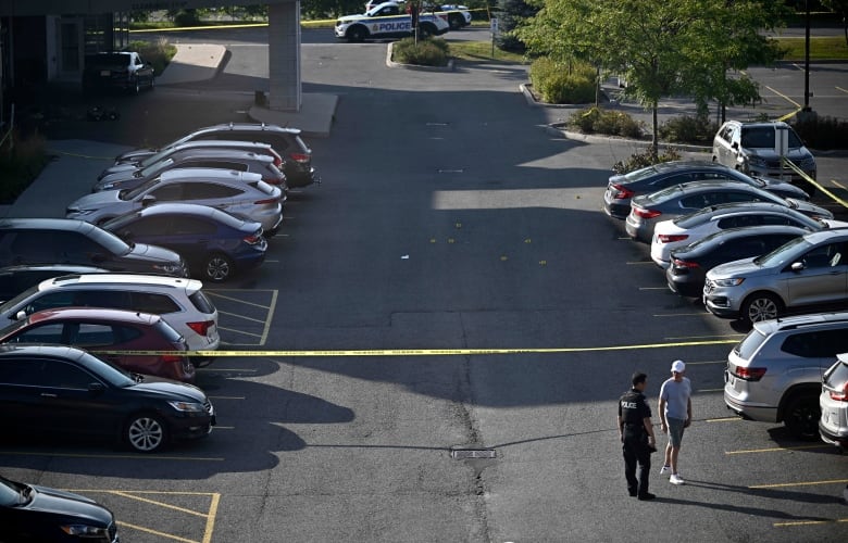 An Ottawa Police officer collects evidence after a Saturday night shooting at the Infinity Convention Centre that left two dead, in Ottawa, on Sunday, Sept. 3, 2023. 